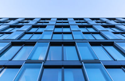 Low angle view of glass building against clear sky