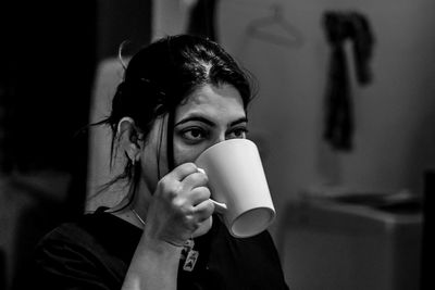 Portrait of young woman drinking coffee