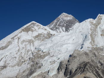 Scenic view of snowcapped mountains against clear blue sky