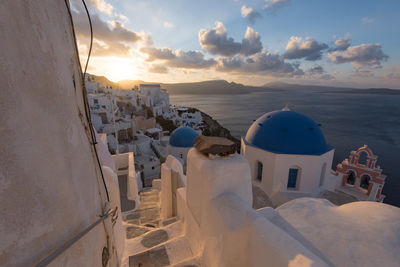 Panoramic view of sea and buildings against sky during sunset