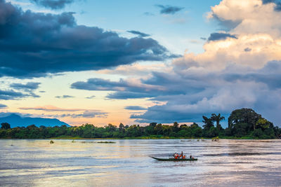 Scenic view of river against sky at sunset