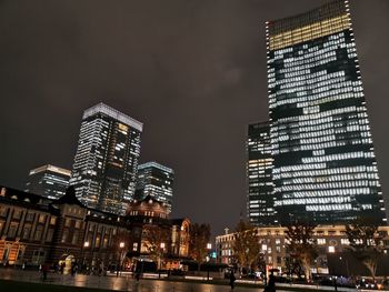 Low angle view of illuminated buildings against sky at night