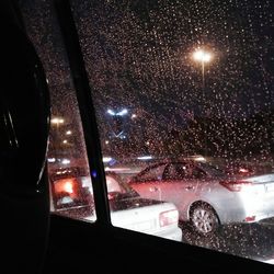 Illuminated street seen through wet glass window