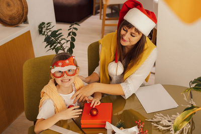A happy family mother and child pack christmas gifts. new year gifts. homemade christmas presents.