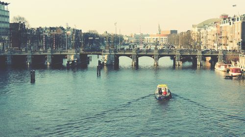 Boats in river with buildings in background