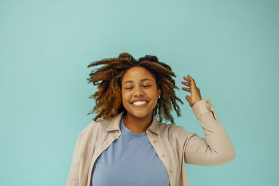 Portrait of smiling young woman against white background