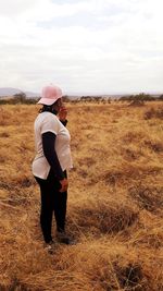 Full length of woman standing on field against sky