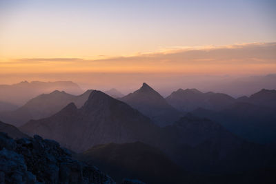 Scenic view of silhouette mountains against sky during sunset