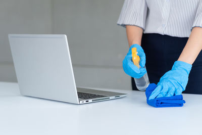 Midsection of man using laptop on table