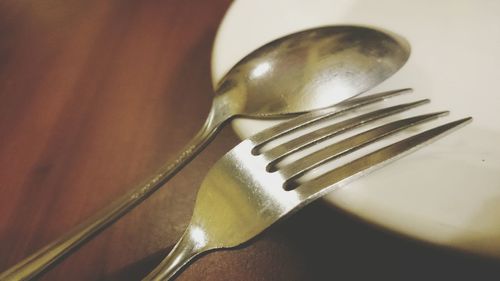 High angle view of fork and spoon on white plate