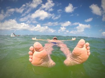 Close-up of man swimming in sea against sky