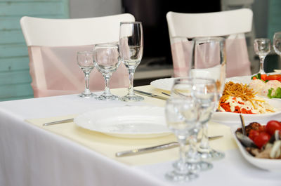 Glass goblets and wine glasses next to a white plate on the banquet table.