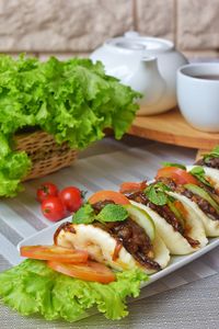 High angle view of steam bun sandwich with salad in plate on table