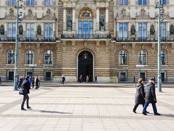 People walking on street against buildings in city