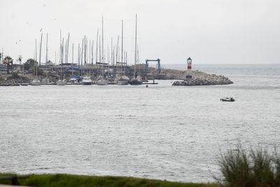 Sailboats in sea against sky