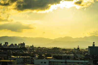 Buildings in city against sky during sunset