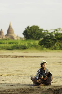 Full length of man sitting on field