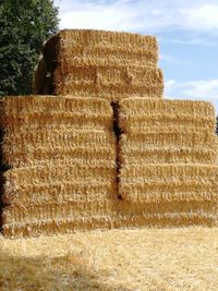 Hay bales on field against sky