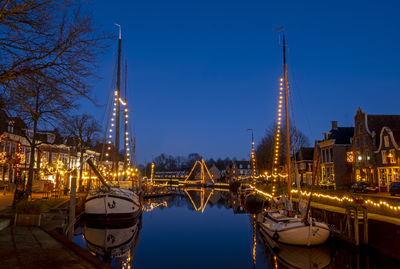 View on enlightened old sailing boats in the city center of dokkum in frieland the netherlands