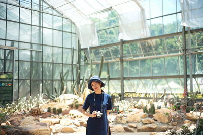 Portrait of woman standing against window