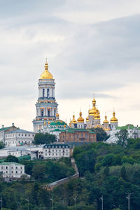 The bell tower of the pechersk lavra and the golden domes of the monastery on the slopes of the kyiv