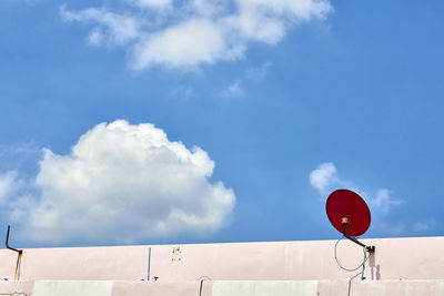 Red satellite dish on brick wall