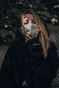 Portrait of beautiful woman with covered mouth