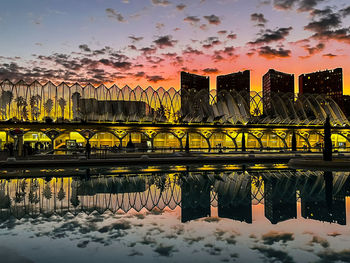 Bridge over frozen lake against sky during sunset