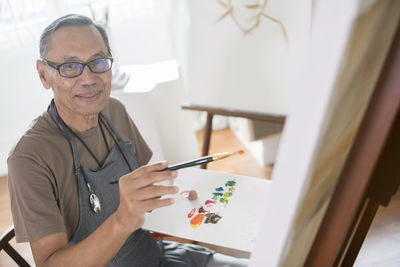 Portrait of man holding eyeglasses