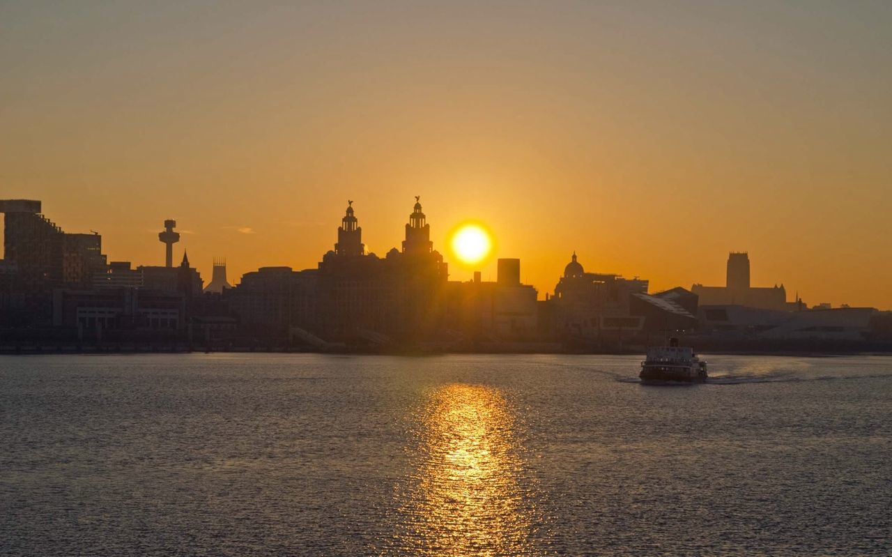 sunset, building exterior, architecture, built structure, sun, clear sky, orange color, city, waterfront, copy space, transportation, water, sunlight, silhouette, mode of transport, river, cityscape, building, outdoors, no people