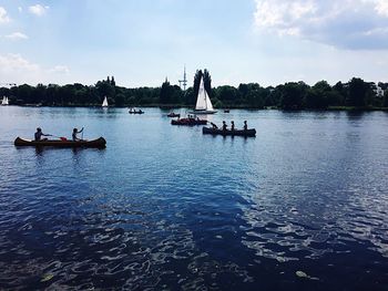 High angle view of people in boat sailing on sea against sky