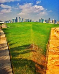 View of grassy field against cloudy sky