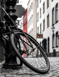 Close-up of bicycle on street against buildings in city