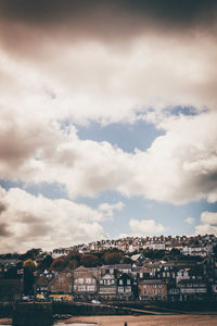 Buildings against cloudy sky