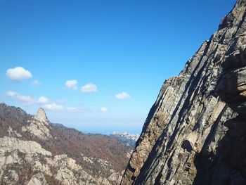 Scenic view of rocky mountains against blue sky