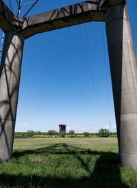 Low angle view of agricultural field against clear blue sky