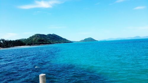 View of calm blue sea against mountain range