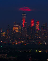 Illuminated cityscape against sky at night