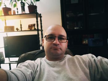 Portrait of man wearing eyeglasses at home