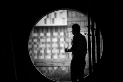 Man looking through circular window