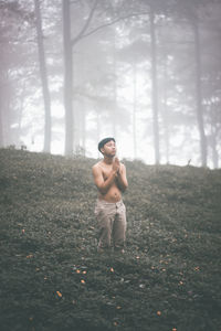 Man standing by plants against trees