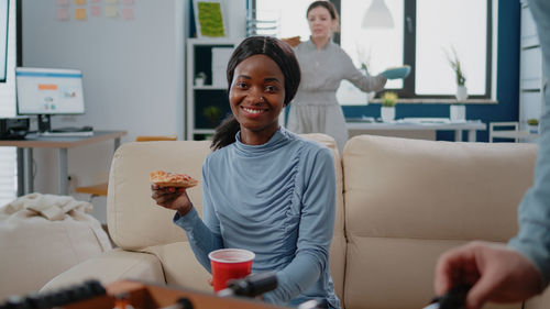 Portrait of friends sitting on sofa