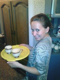 Portrait of smiling woman holding drink at table