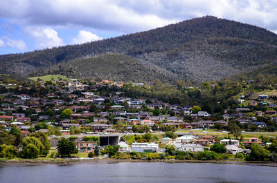 Aerial view of townscape by mountain against sky