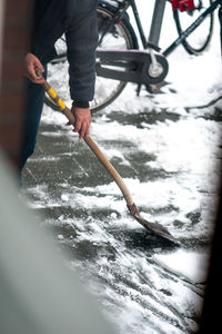 Low section of person holding ice during winter