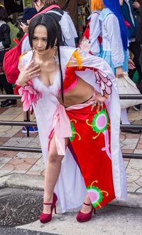 Woman with arms outstretched standing against red umbrella