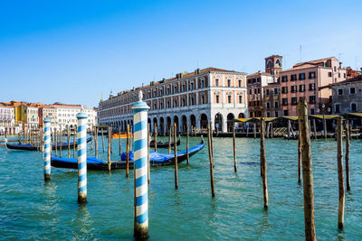 Wooden posts and gondolas on grand canal in city