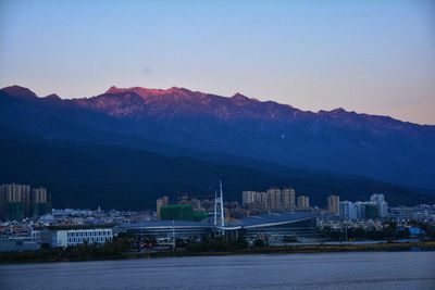 View of city lit up against mountain range