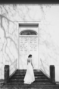 Rear view of woman standing against wall
