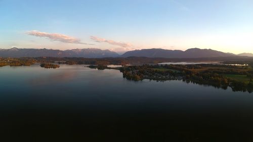 Scenic view of lake by mountains against sky